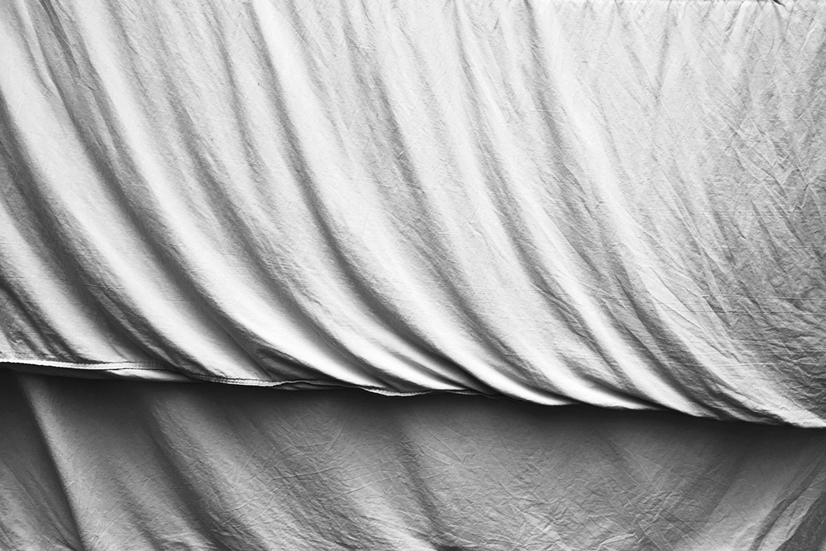 Gros plan sur un drap blanc froissé aux plis doux