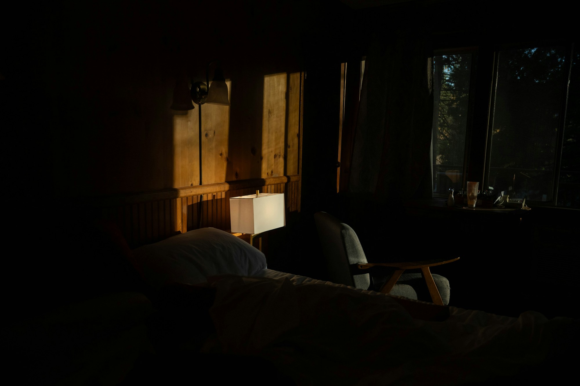 Chambre calme dans la penombre du soir, lampe de chevet allumee